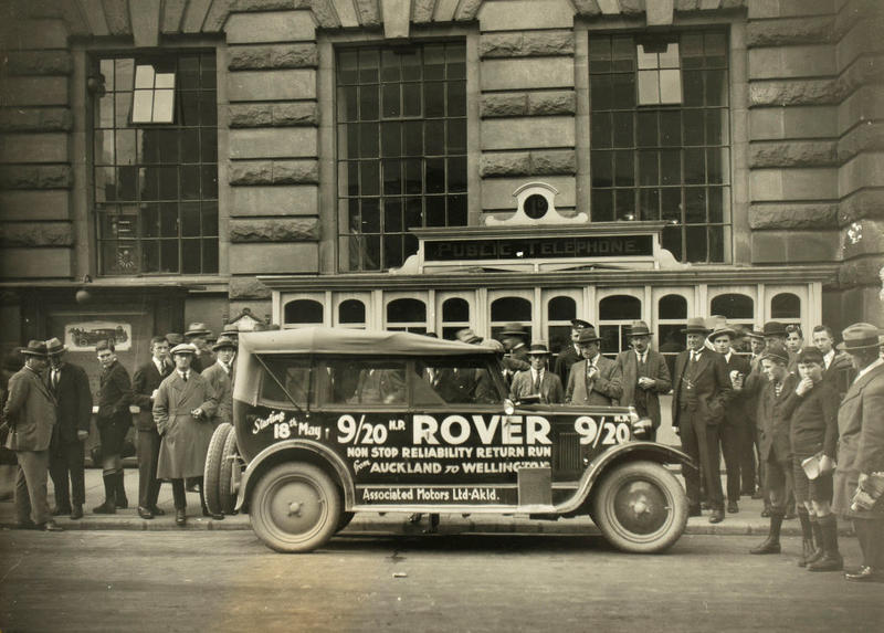 (Rover with advertising and street spectators)